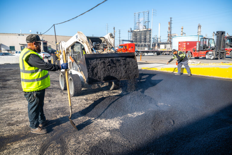 Professional asphalt contractor crew paving residential driveway